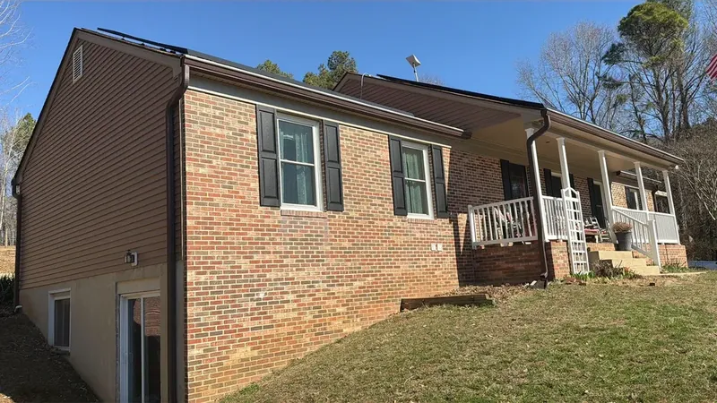 New asphalt shingle roof and seamless gutters on a brick rancher with brown vinyl siding in Leonardtown, MD
